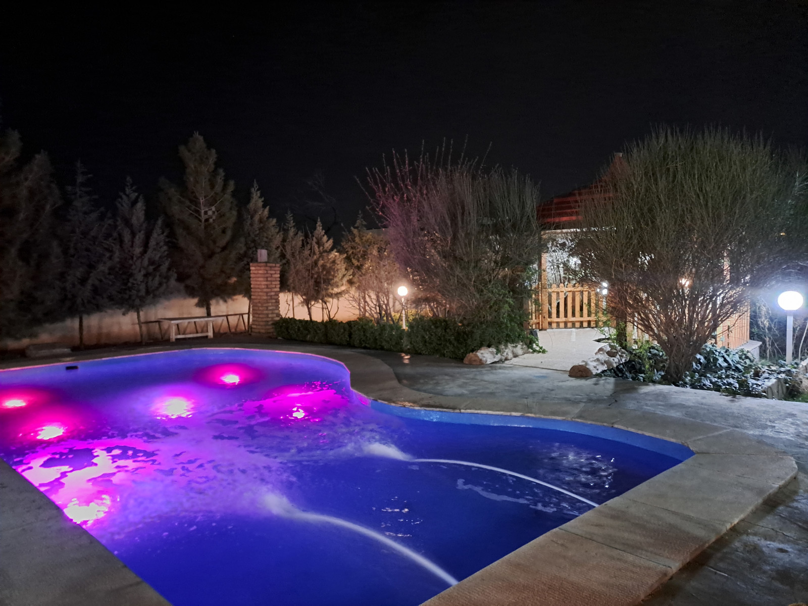 نمای استخر در شب به همراه نورپردازی