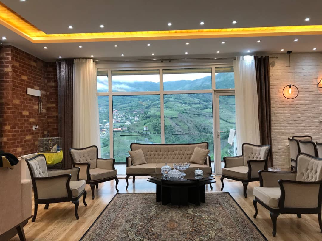 پذیرایی شامل میز ناهارخوری  یک دست مبل نیمه استیل و یک دست مبل راحتی جلوی تی وی وال میباشد.