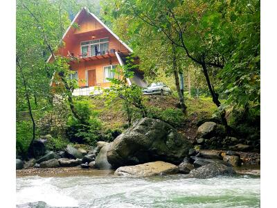 کلبه چوبی "امیر" دربست لب رودخانه و در جنگل